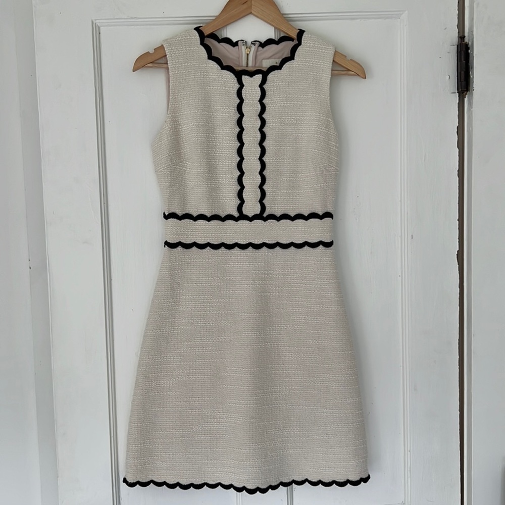 Kate Spade, cream color with black scalloped details. Lined with gold zipper.